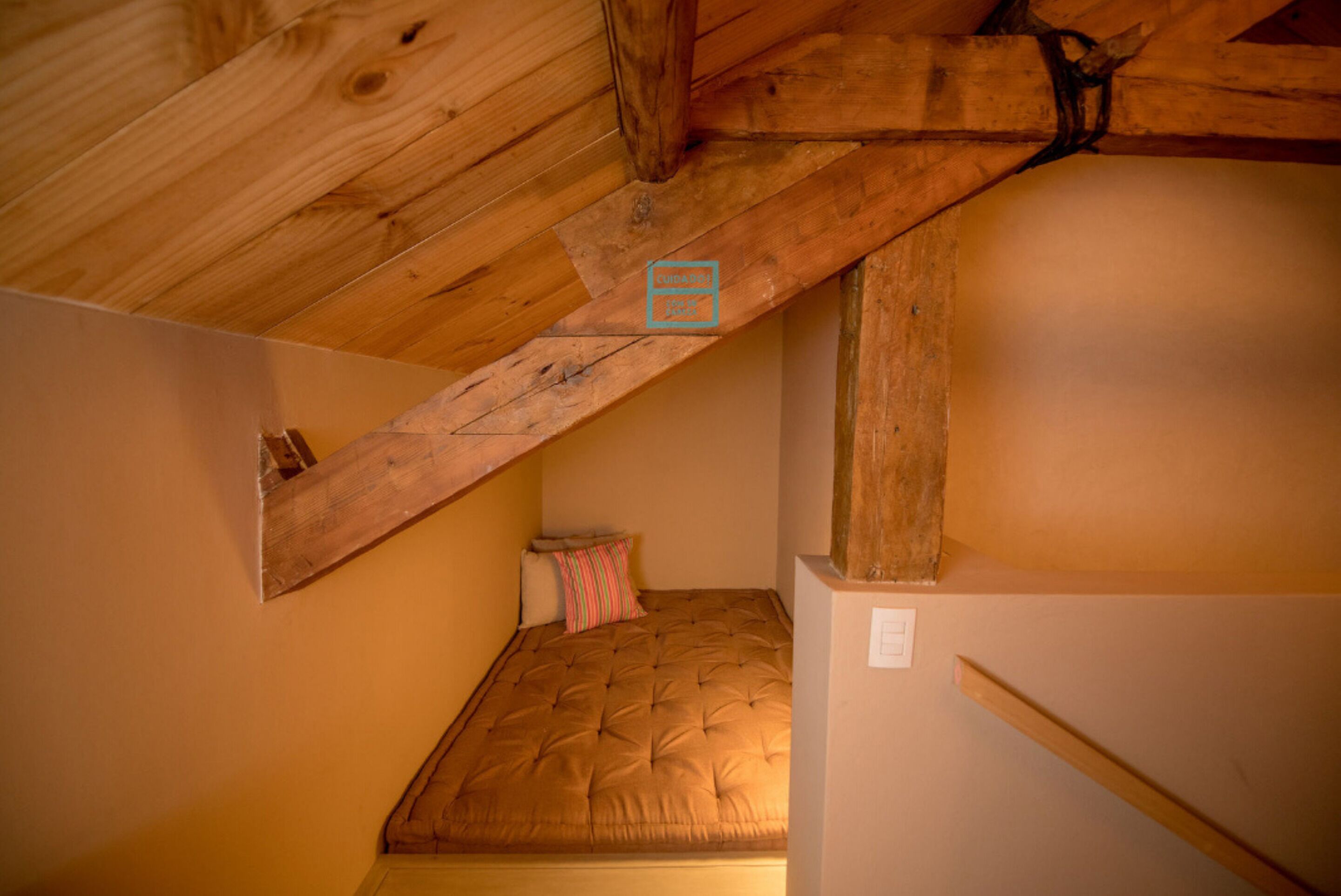 Une petite pièce agréable, dotée d’un plafond en pente et de poutres en bois.