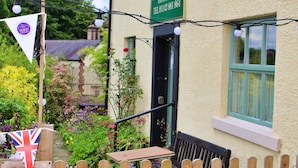 A wooden gate with a sign indicating a "Cheese and Care" path/steps are slippery when wet. - Wortley Cottage Guest House (Sheffield)