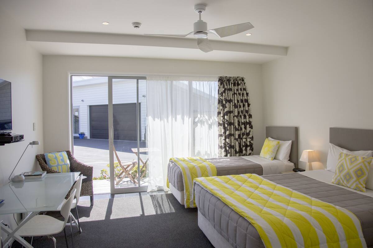 Una habitación de hotel con dos camas, un escritorio y una silla.
