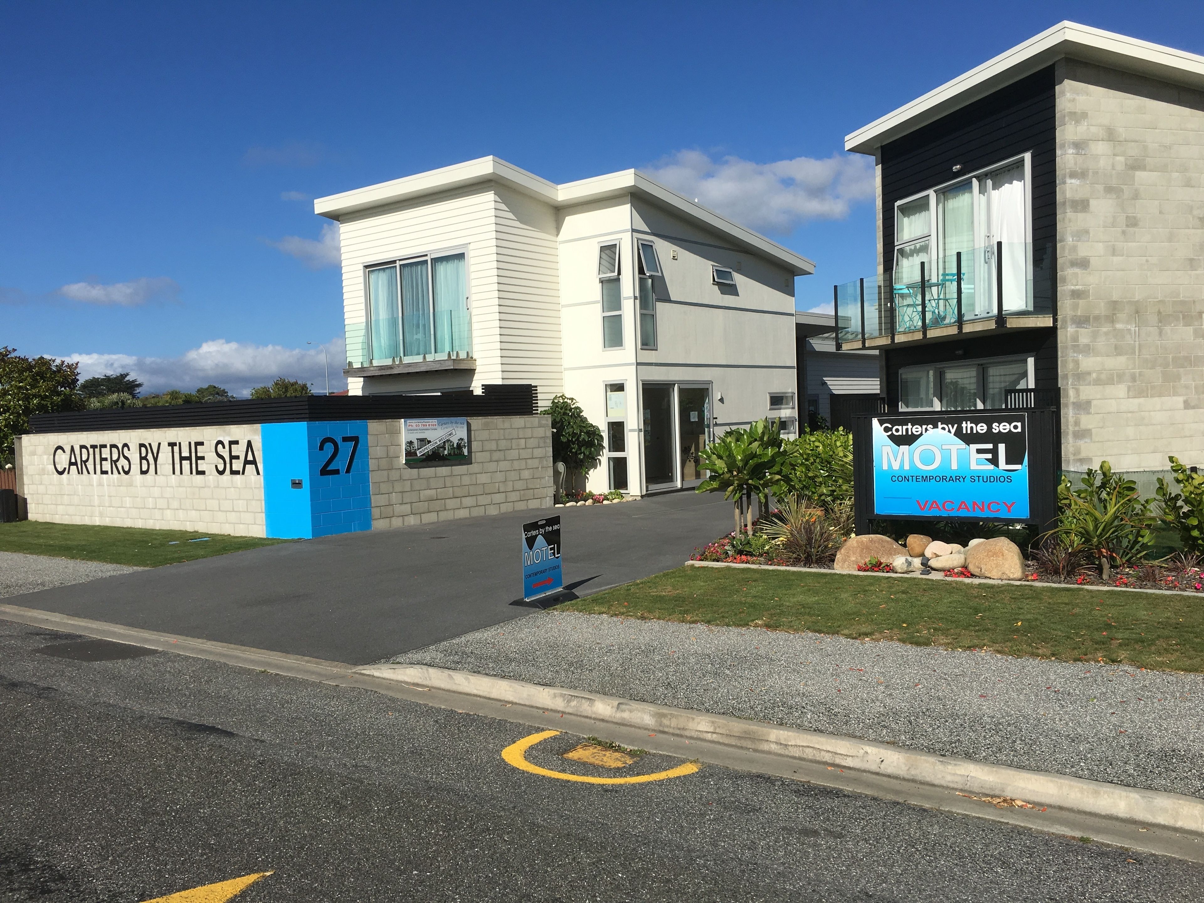 A modern building with a sign indicating 'CARTERS BY THE SEA' and 'MOTEL'.