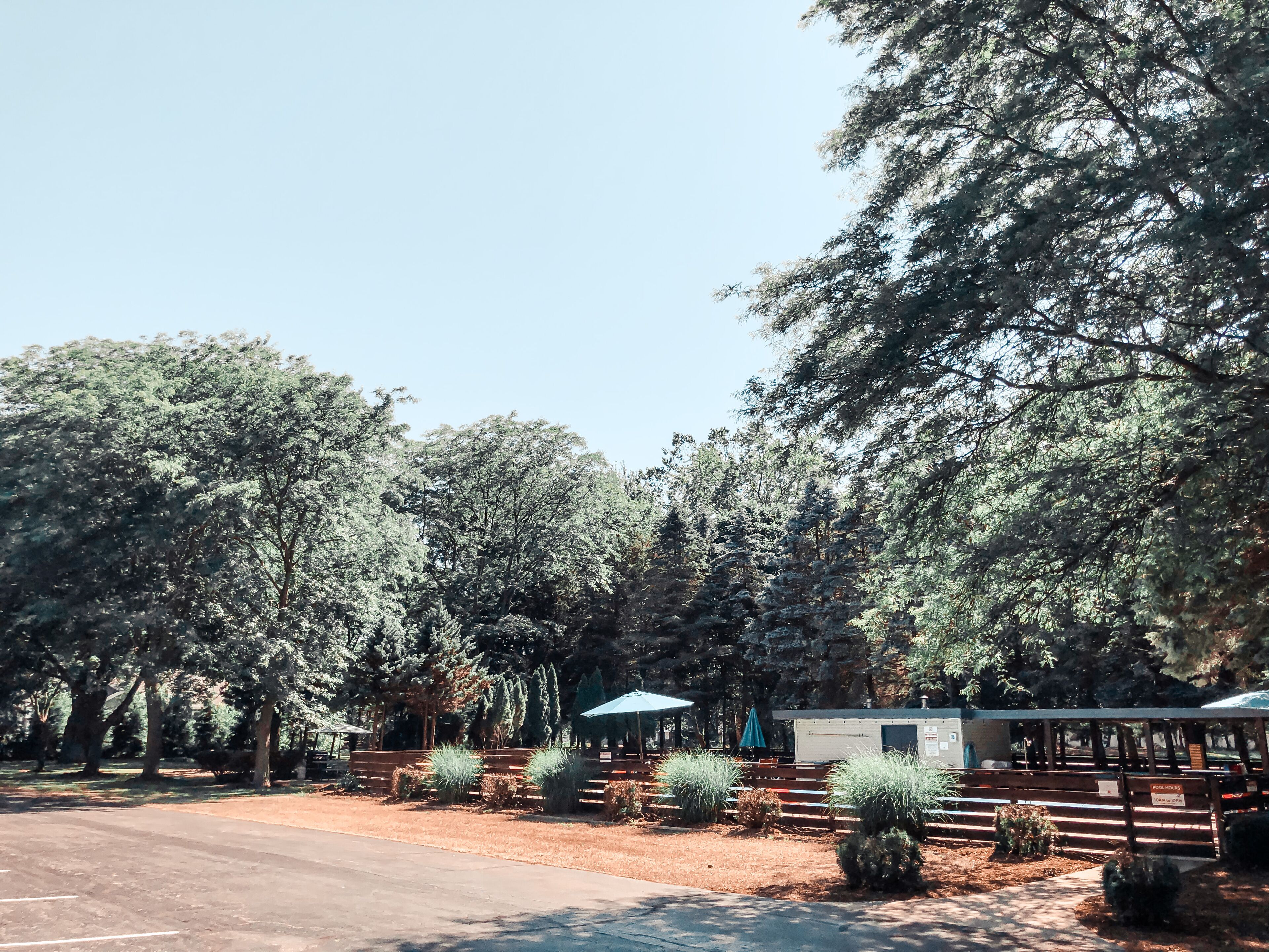 A campground with picnic tables, a small cabin, and a fenced area.