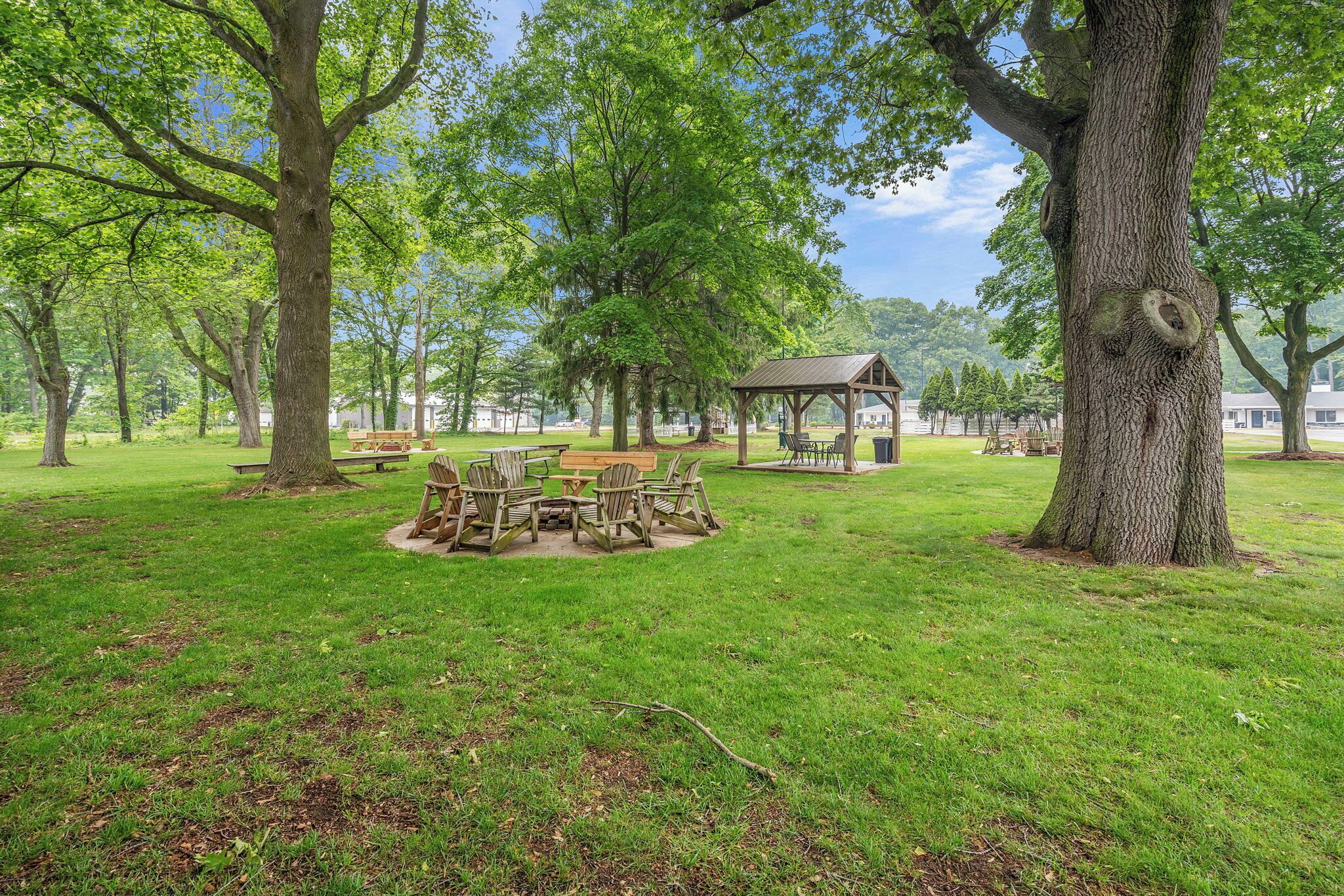 A park with a wooden gazebo, picnic tables, and benches.