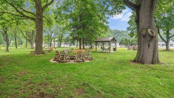 A park with a wooden gazebo, picnic tables, and benches.