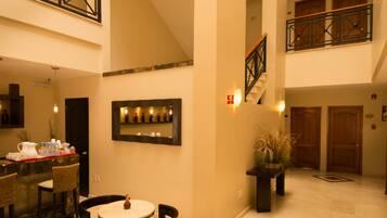 A spacious interior with a dining area, a staircase, and a balcony.