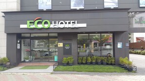 The exterior of ECO Hotel with a modern design, large glass windows, and a green lawn area in front. - Eco Hotel (Pohang)