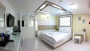 A modern hotel room with a bed, bedside table, and a TV. - Eco Hotel (Pohang)