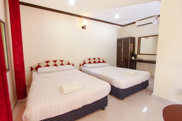 A hotel room with two beds, a red curtain, a mirror, and an air conditioning unit.