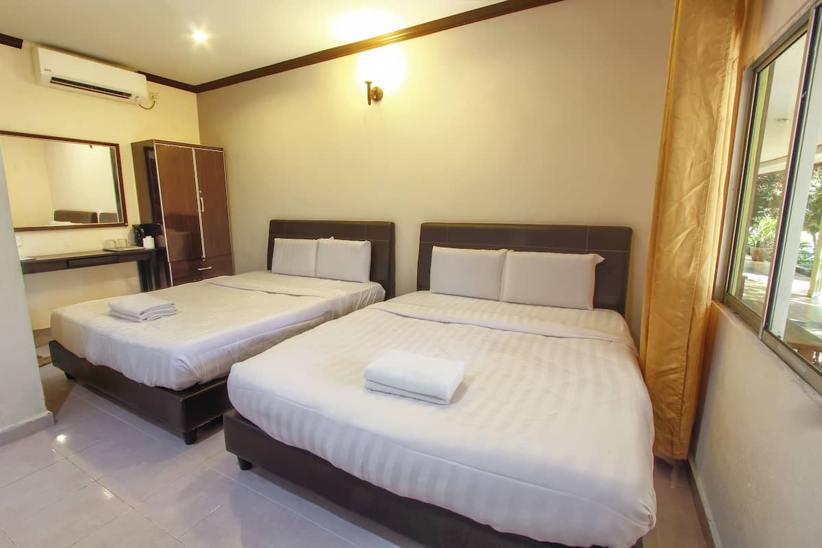 A hotel room with two beds, a wardrobe, a mirror, and an air conditioning unit.