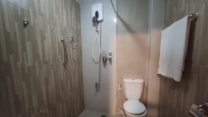 A bathroom with a shower, toilet, and sink. - Nikita's Place Hotel (Calapan)