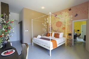 A four-poster bed with a white frame, a floral wall mural, and a small table with a lamp. - Play La Ploen Boutique Resort (Khu Mueang)