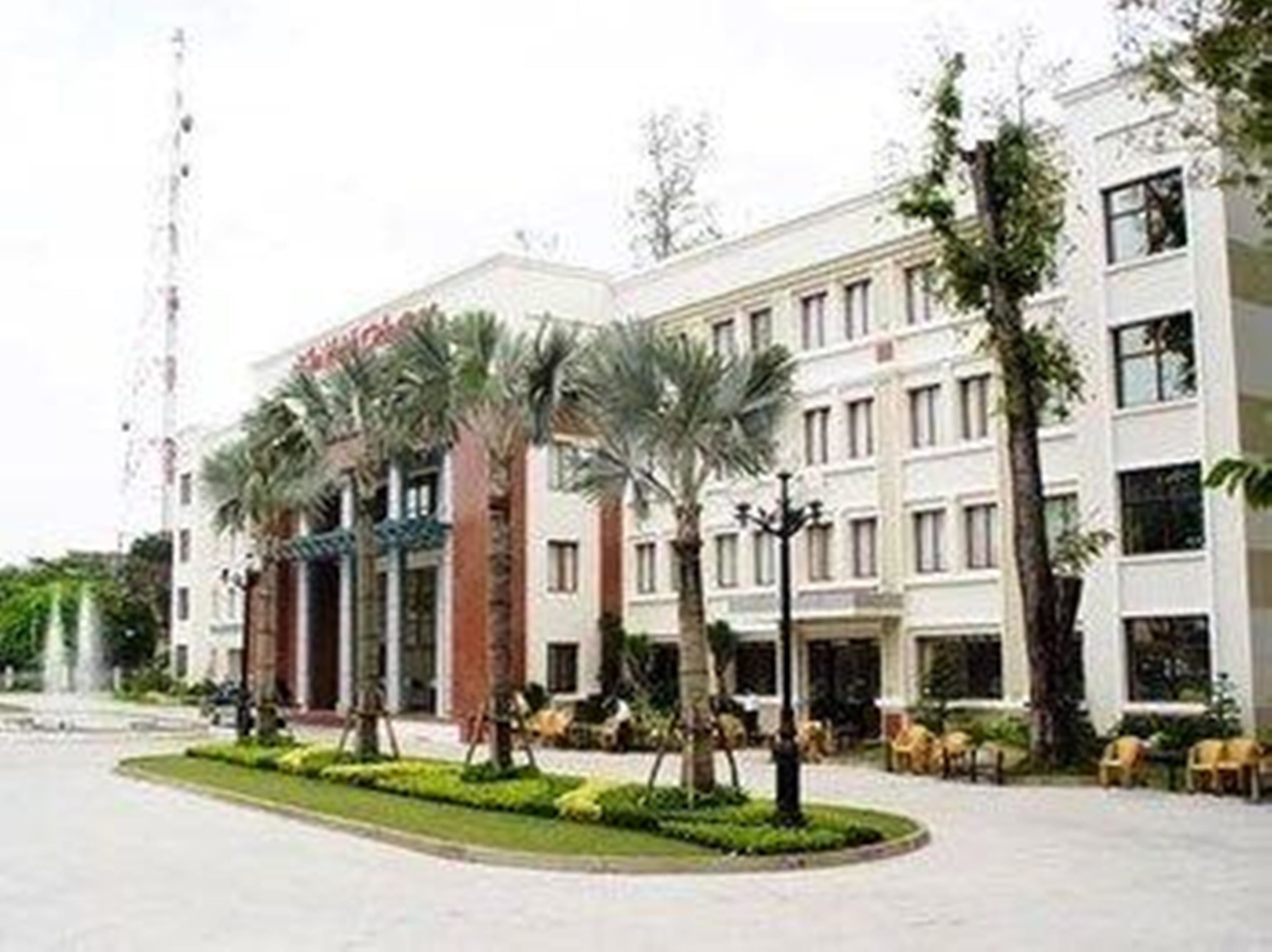 A hotel with a central courtyard, palm trees, and a fountain.