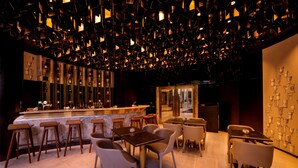 A modern bar area with a bar counter, stools, and tables. - Kowloon Harbourfront Hotel (Kowloon)