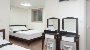 Quarto de hotel com cama, toucador com espelhos, janela e aparelho de ar condicionado.