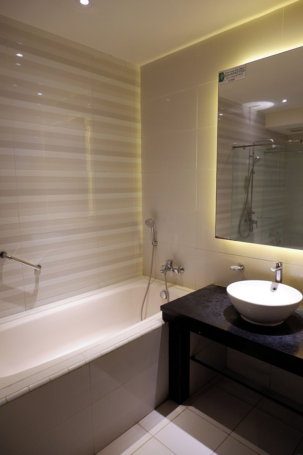 A modern bathroom with a bathtub, a sink, and a mirror.