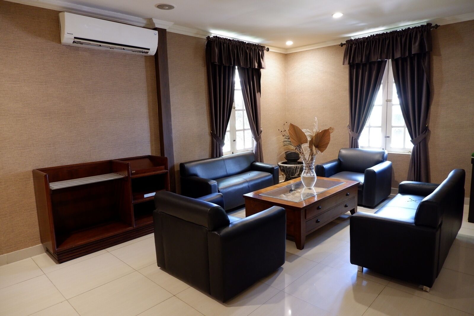 A modern living room with a sofa set, a coffee table, and a bookshelf.