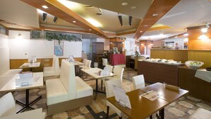 A restaurant with booths and tables, a counter with food, and a patterned floor.