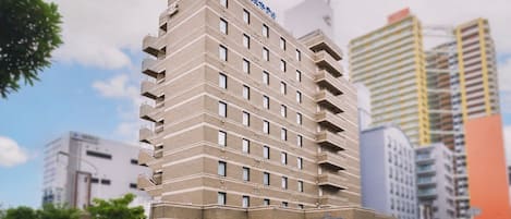Un hotel de varios pisos con diseño moderno, que destaca por su entrada imponente y una serie de balcones.