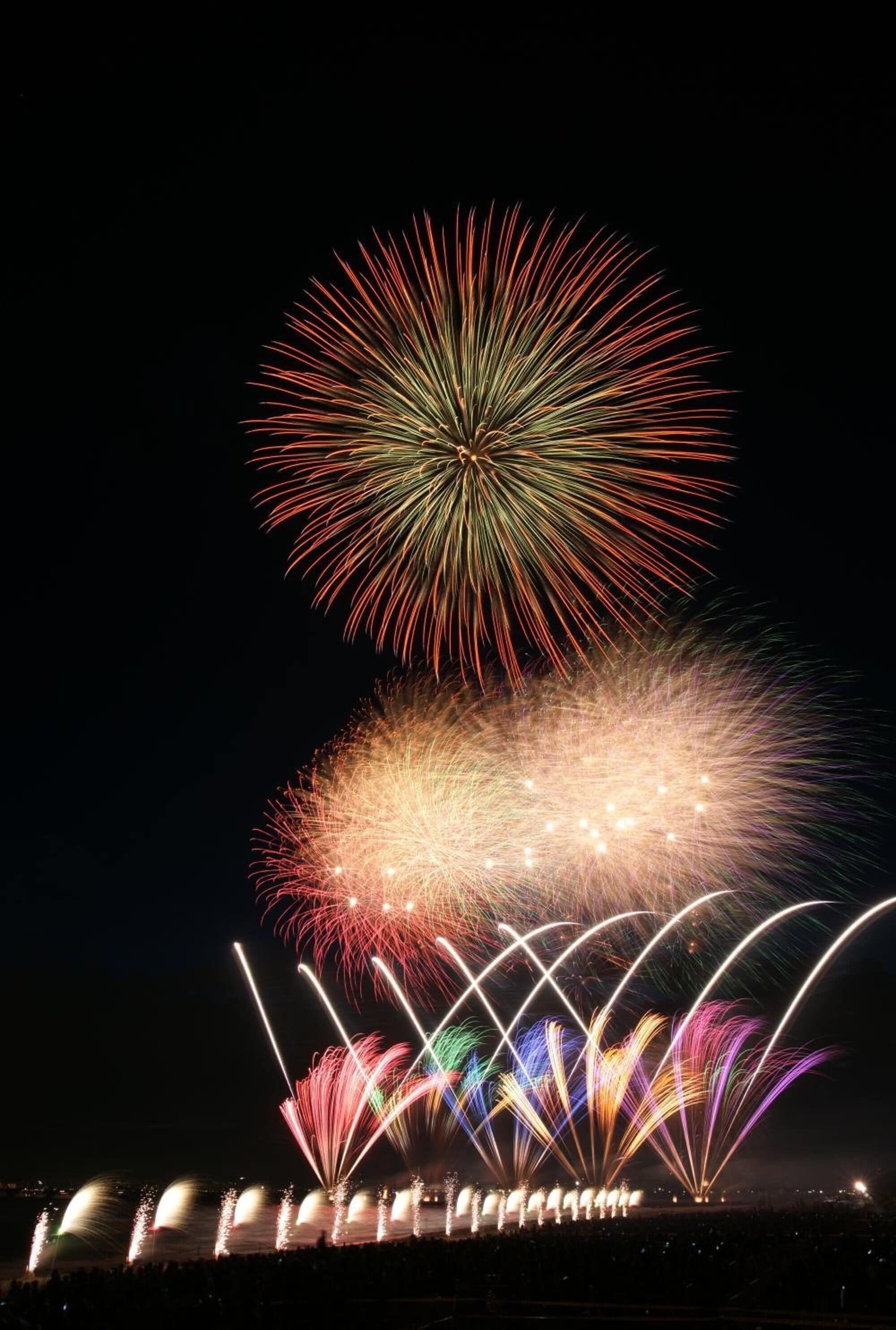 Espectáculo de fuegos artificiales nocturnos con múltiples destellos de luz.