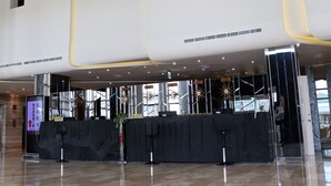 A spacious lobby with a high ceiling, a reception desk, and a modern staircase. - Look Royal Resort (Chiayi City)