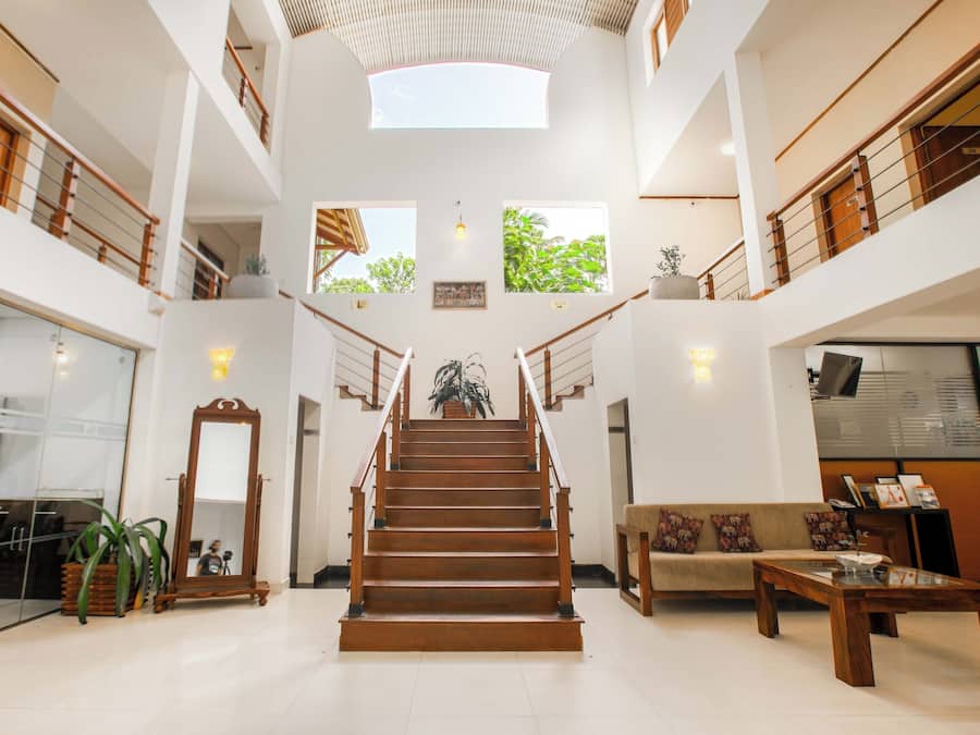 A spacious interior with a central staircase, multiple levels, and natural light from skylights.