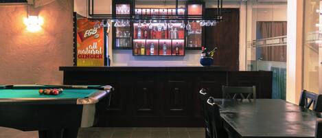 A bar area with a pool table and a billiards setup.