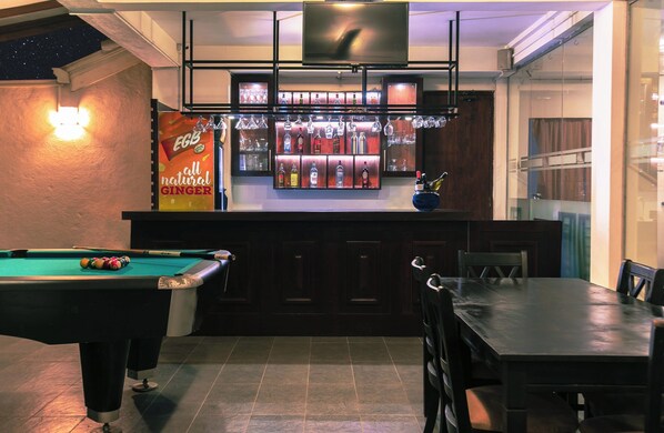 Zona de bar con mesa de billar y equipo de billar.