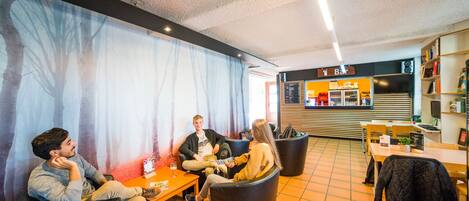 A modern interior with seating areas, a bar, and a menu board.