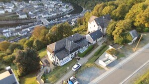 Vista aérea de una zona residencial con una casa destacada, que cuenta con un garaje grande y una entrada para vehículos.