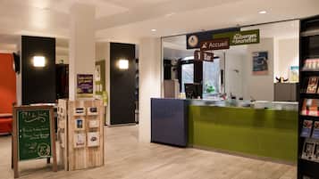 Een hotel receptie met een groen aanrecht, een prikbord en een informatiebord.