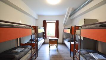 Un dormitorio con literas, un escritorio y una silla.