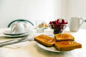 A breakfast setting with toast, a cup, and a bowl of fruit on a table. - B&B Back to Sorrento (Sant'Agnello)