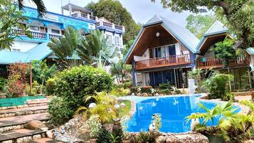 Una piscina al aire libre, sillones reclinables de piscina