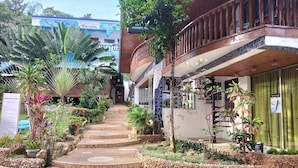 A hotel entrance with a stone staircase leading to a wooden balcony. - Princess of Coron (Coron)