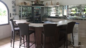 A modern kitchen with a central island, bar stools, and a refrigerator stocked with beverages. - Princess of Coron (Coron)