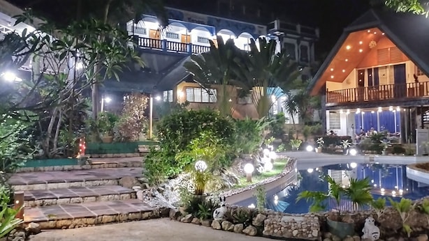 A well-lit outdoor area with a pool, stone steps, and lush greenery. - Princess of Coron (Coron)