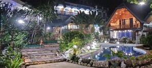 A well-lit outdoor area with a pool, stone steps, and lush greenery. - Princess of Coron (Coron)