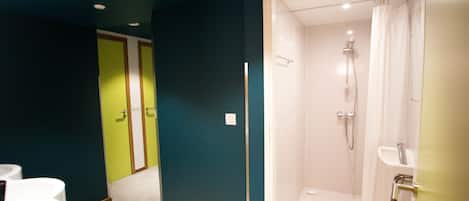 A bathroom with a shower, toilet, and sink.
