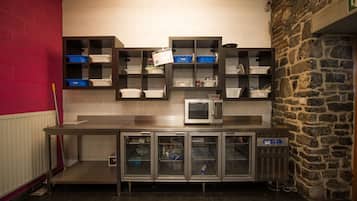 Een keuken met roestvrijstalen apparatuur, opbergkasten en een magnetron.