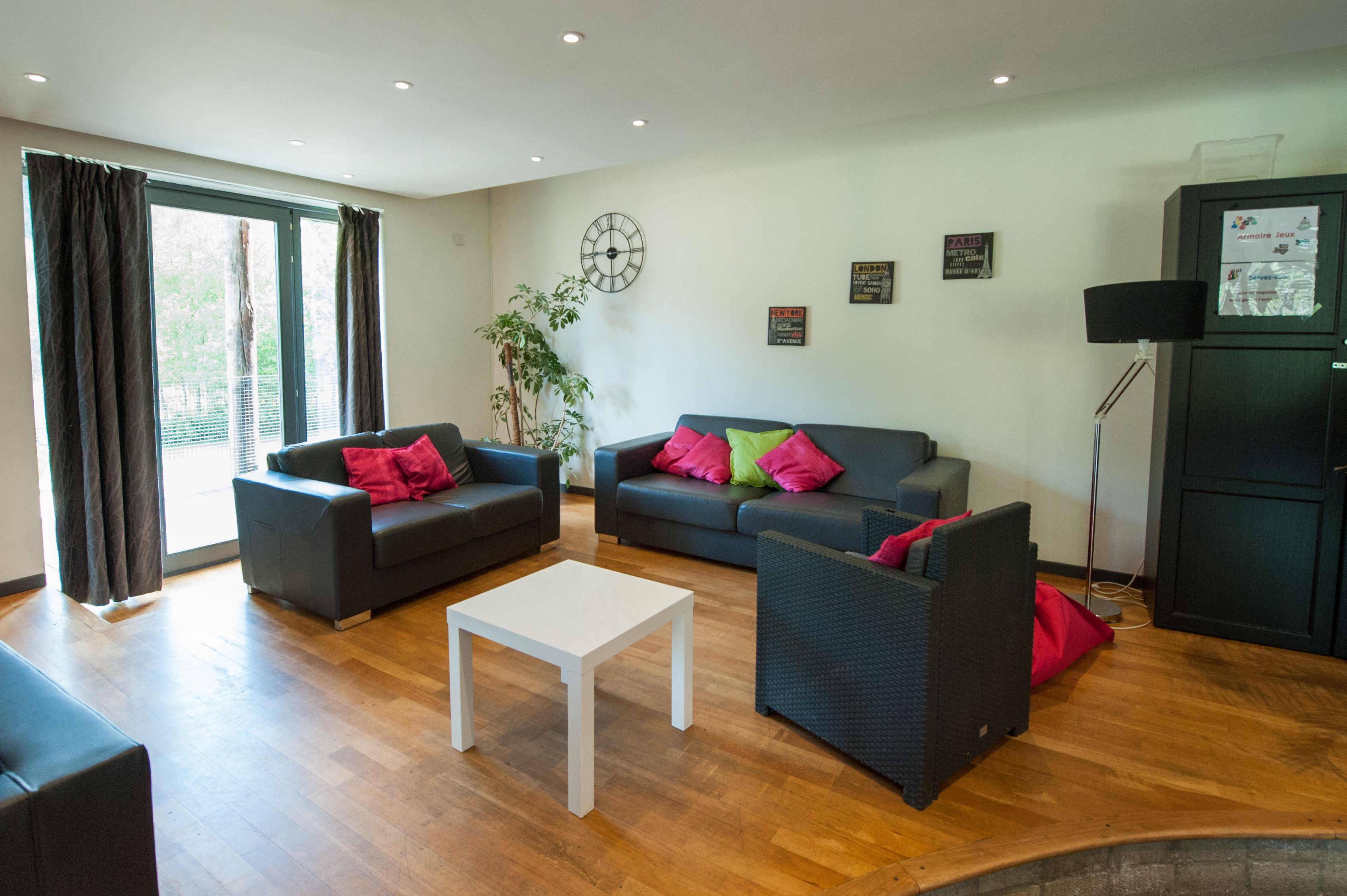 A modern living room with two sofas, a white coffee table, and a black cabinet.