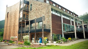 A modern building with a wooden facade, large windows, and a balcony. - Malmedy Youth Hostel (Malmedy)