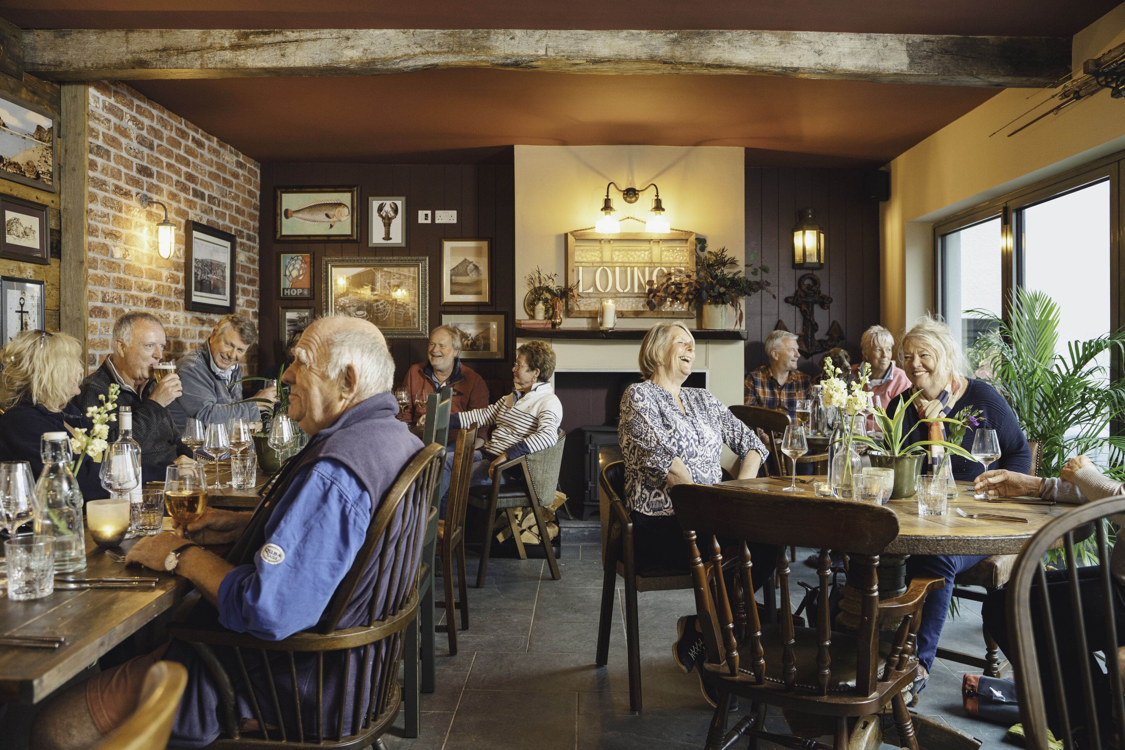 A cozy restaurant with brick walls, wooden furniture, and a 'Lounge' sign.