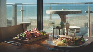 A table with a meal, a glass of water, and a view of the ocean. - Hope & Anchor (Kingsbridge)