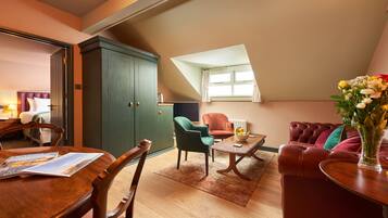 A cozy living room with a dining area, a green cabinet, and a red sofa.