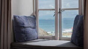 A window seat with two cushions, overlooking a rocky coastline and the sea. - Hope & Anchor (Kingsbridge)