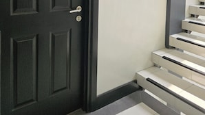 A black door with a number plate '301', a stairway with white steps, and a light fixture above the door. - First Pacific Inn (Davao)