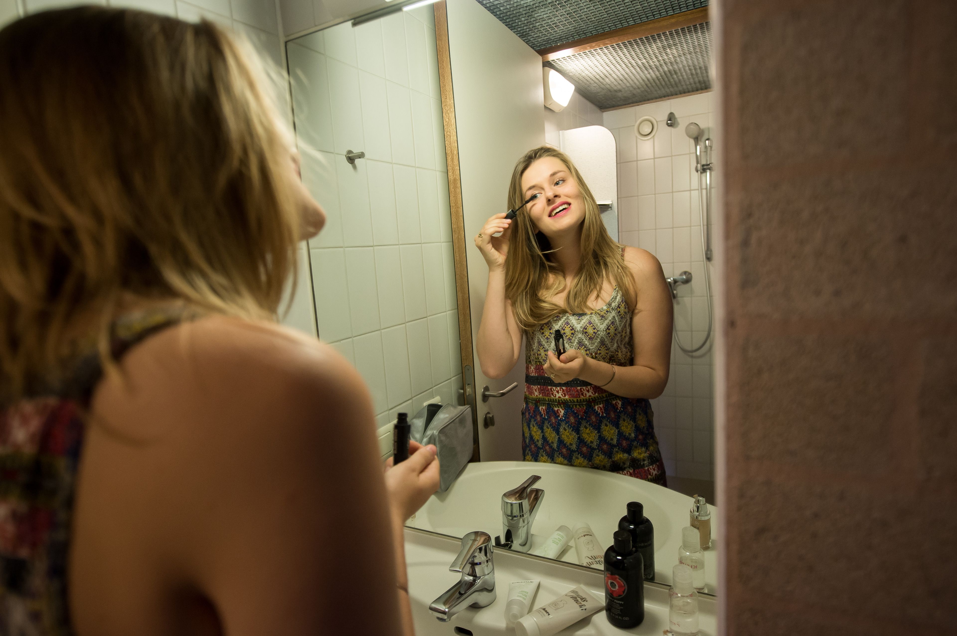 Un baño con espejo, lavabo y artículos de aseo.