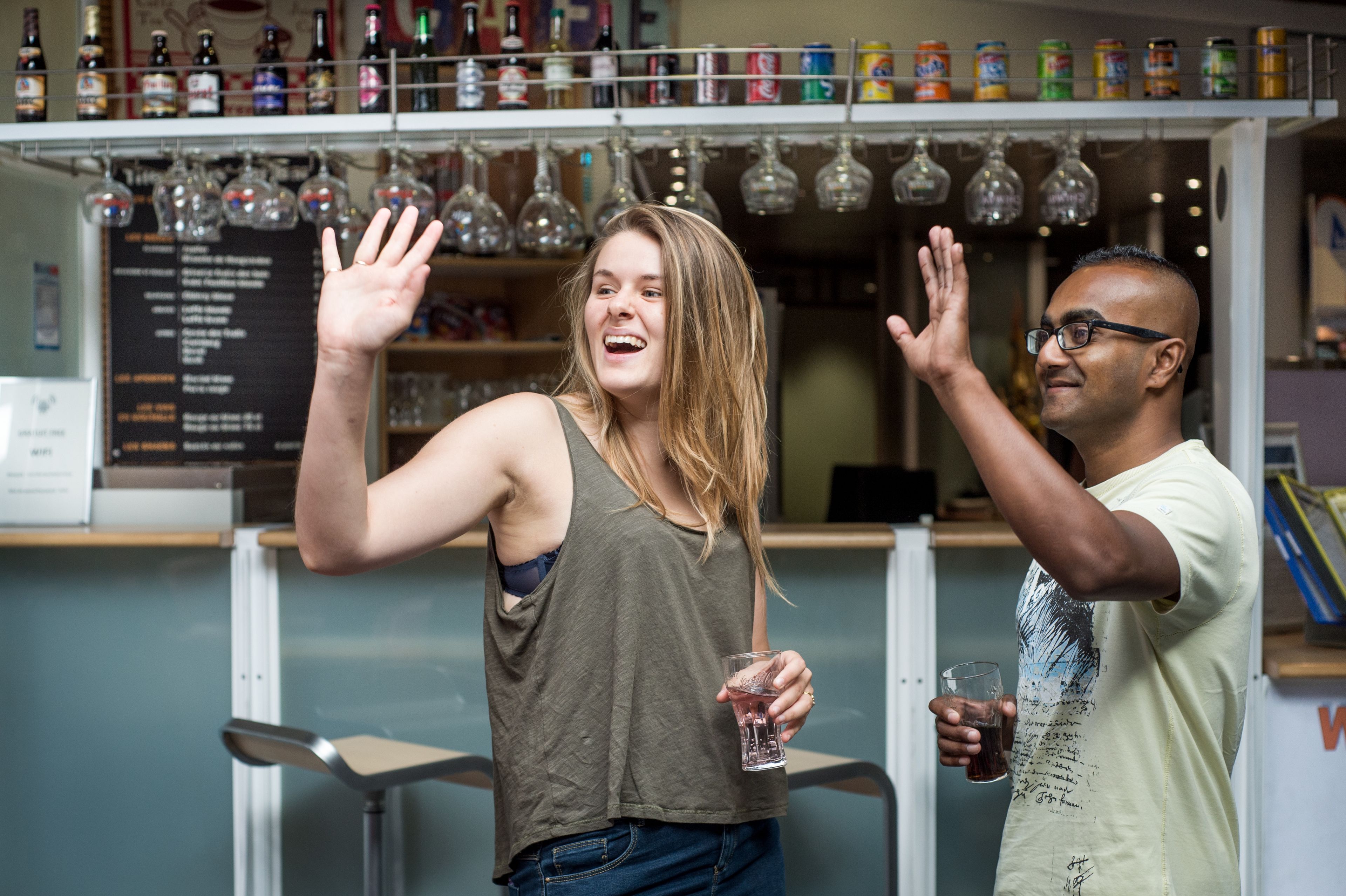 Een bar met flessen en glazen op de planken.