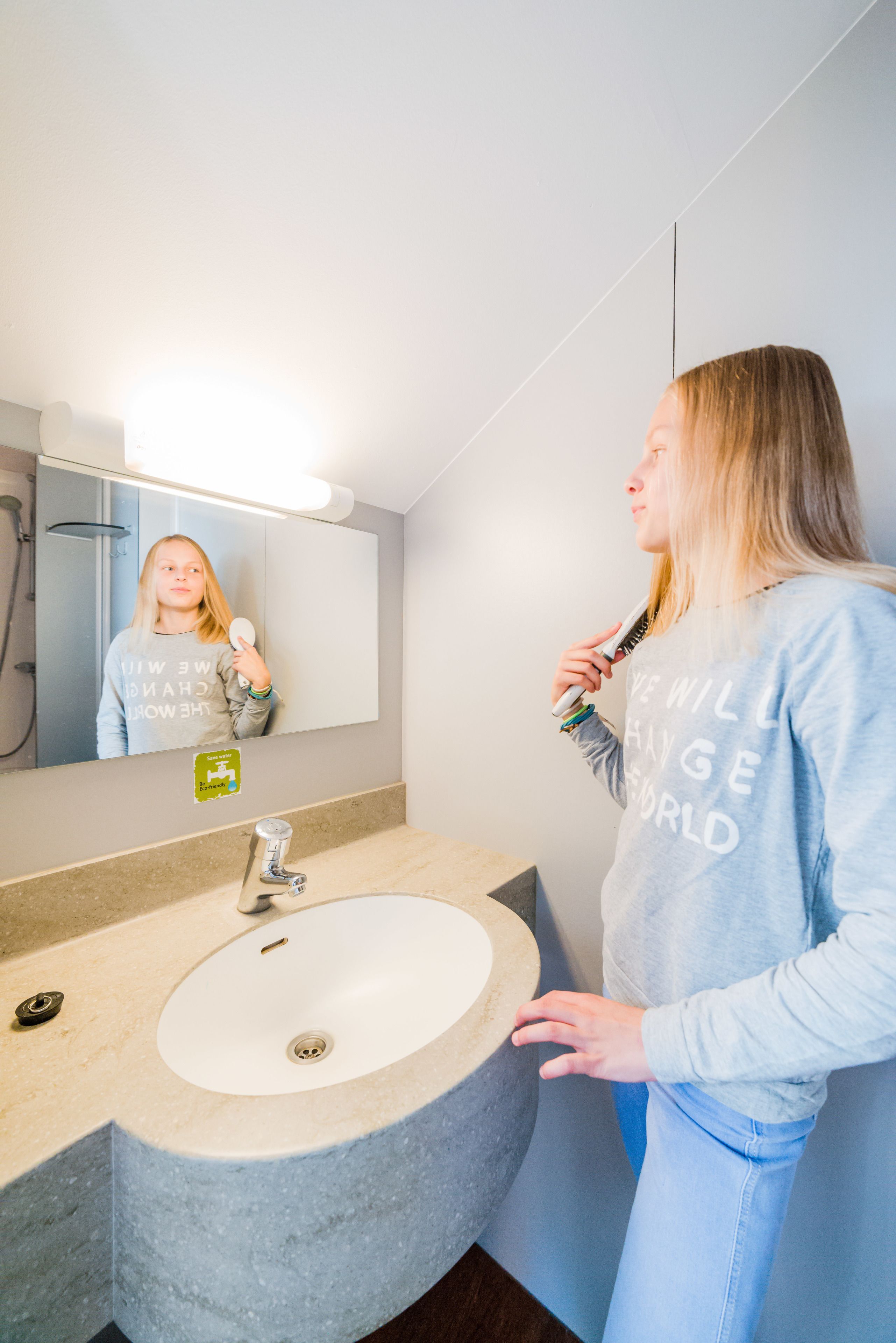 A bathroom with a sink, mirror, and shower.