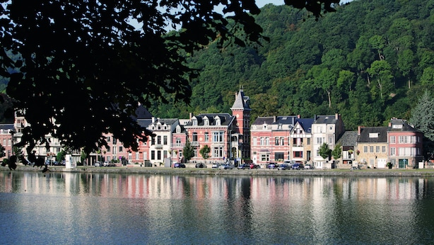 A waterfront town with historic buildings, a central tower, and a calm river reflecting the architecture. - Auberge de Jeunesse de Namur - Hostel (Namur)
