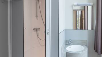 A modern bathroom with a shower, a sink, and a mirror.